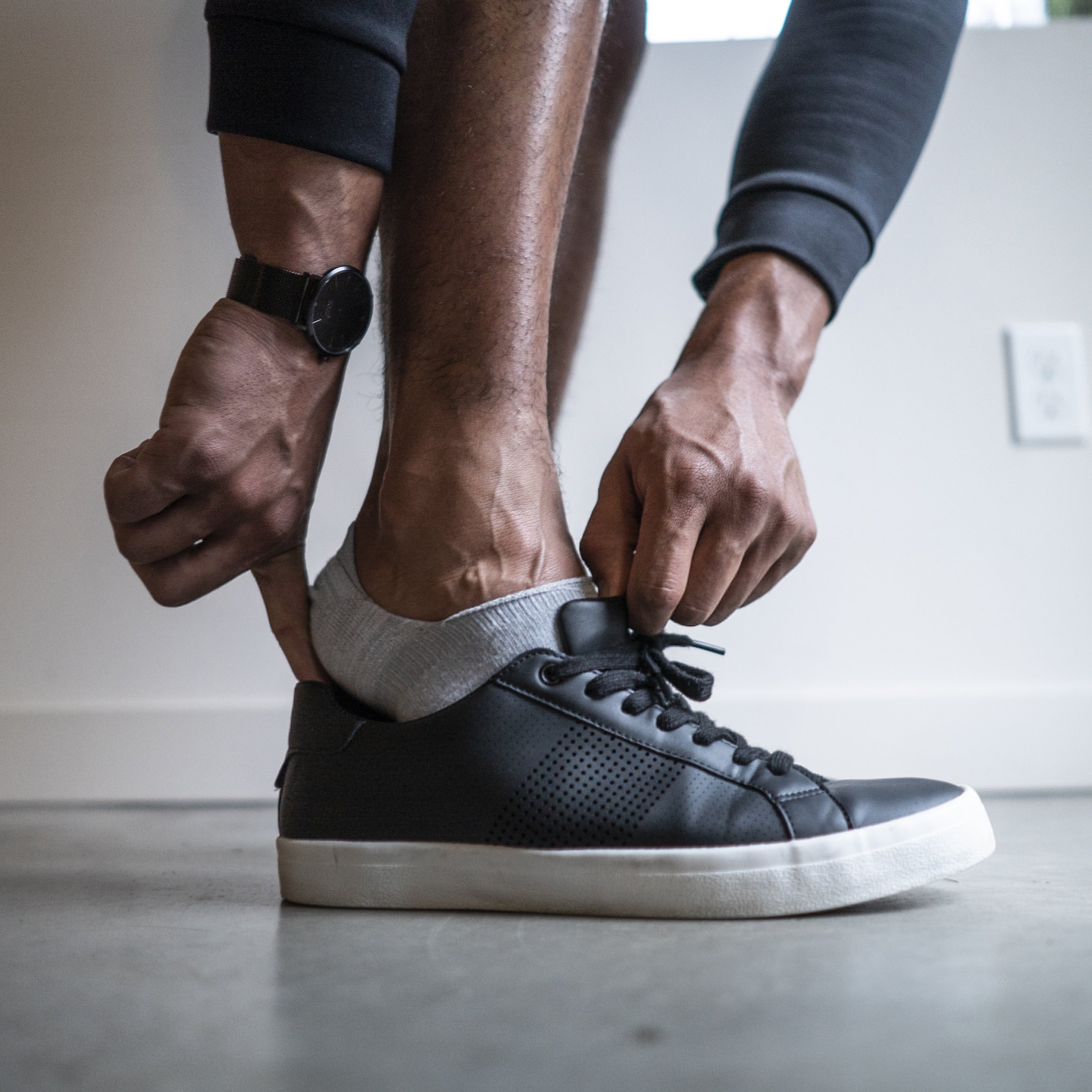 Basic no-show socks in gray worn with black sneakers, providing a discreet look.